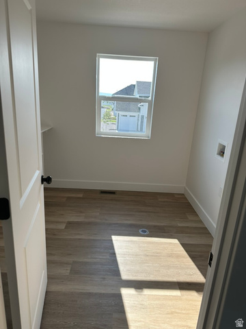 1886 North 300 West Logan, UT 84341 - Photo 12 of 18 Room featuring wood-finish flooring, a contemporary window, and white painted walls and built in shelf.