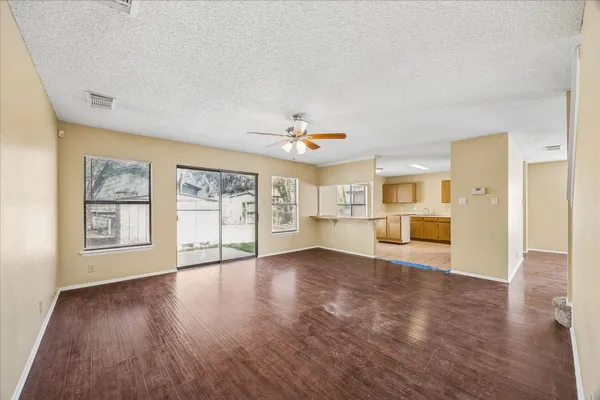 a view of an empty room with a window and wooden floor
