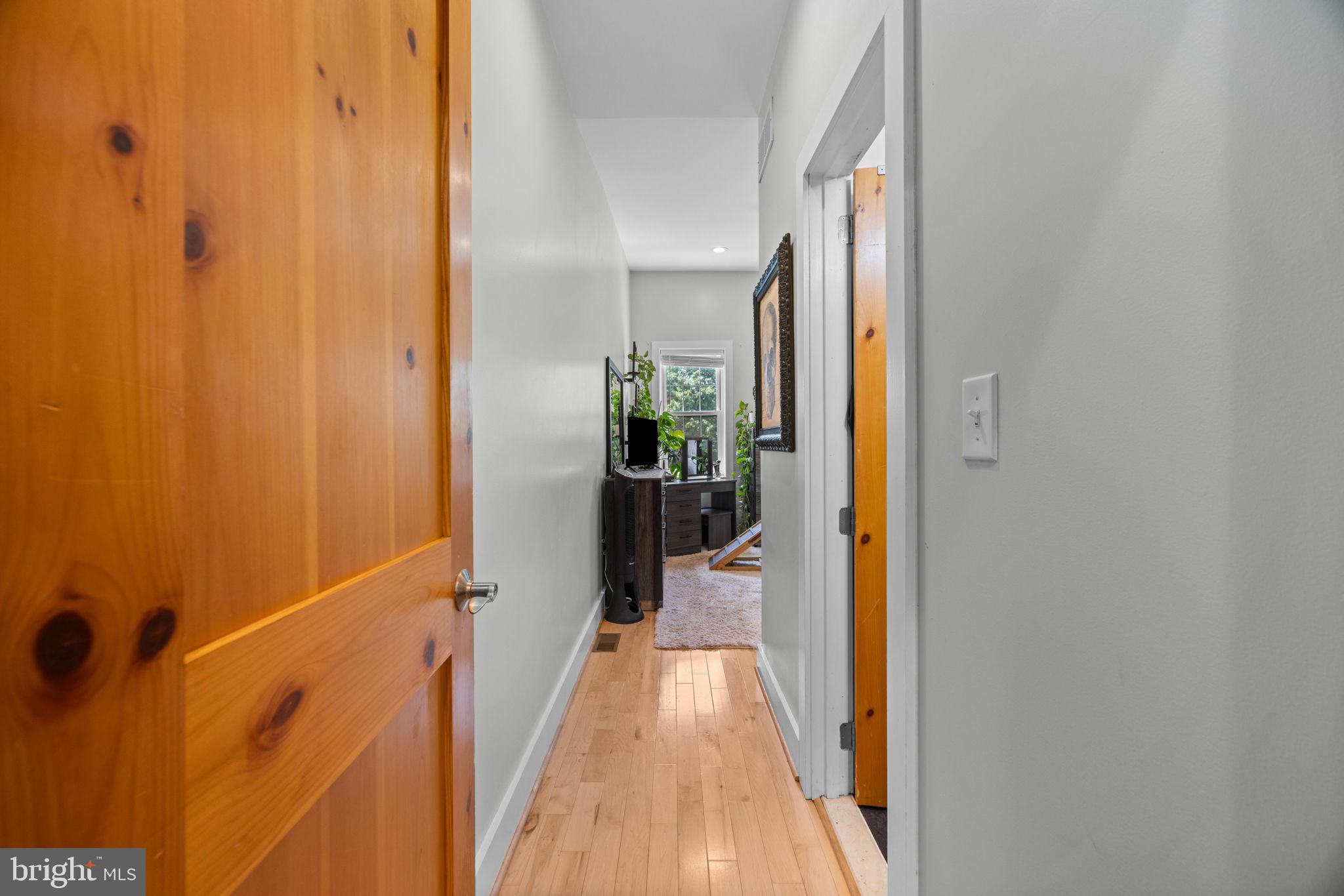 3208 Elliott Street Baltimore, MD 21224 - Photo 23 of 42 a view of a hallway with wooden floor and a bathroom