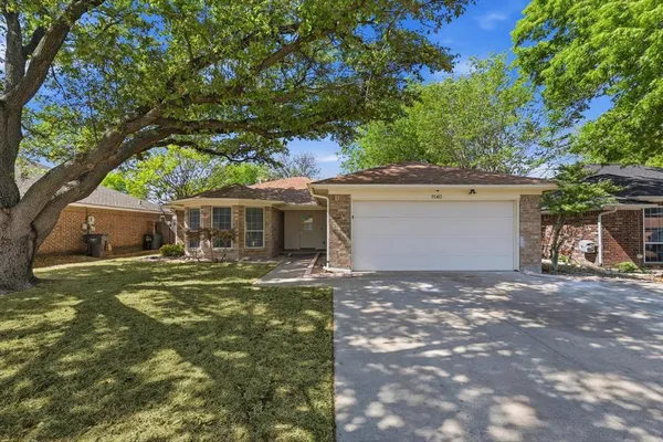 a backyard of a house with table and chairs under an umbrella