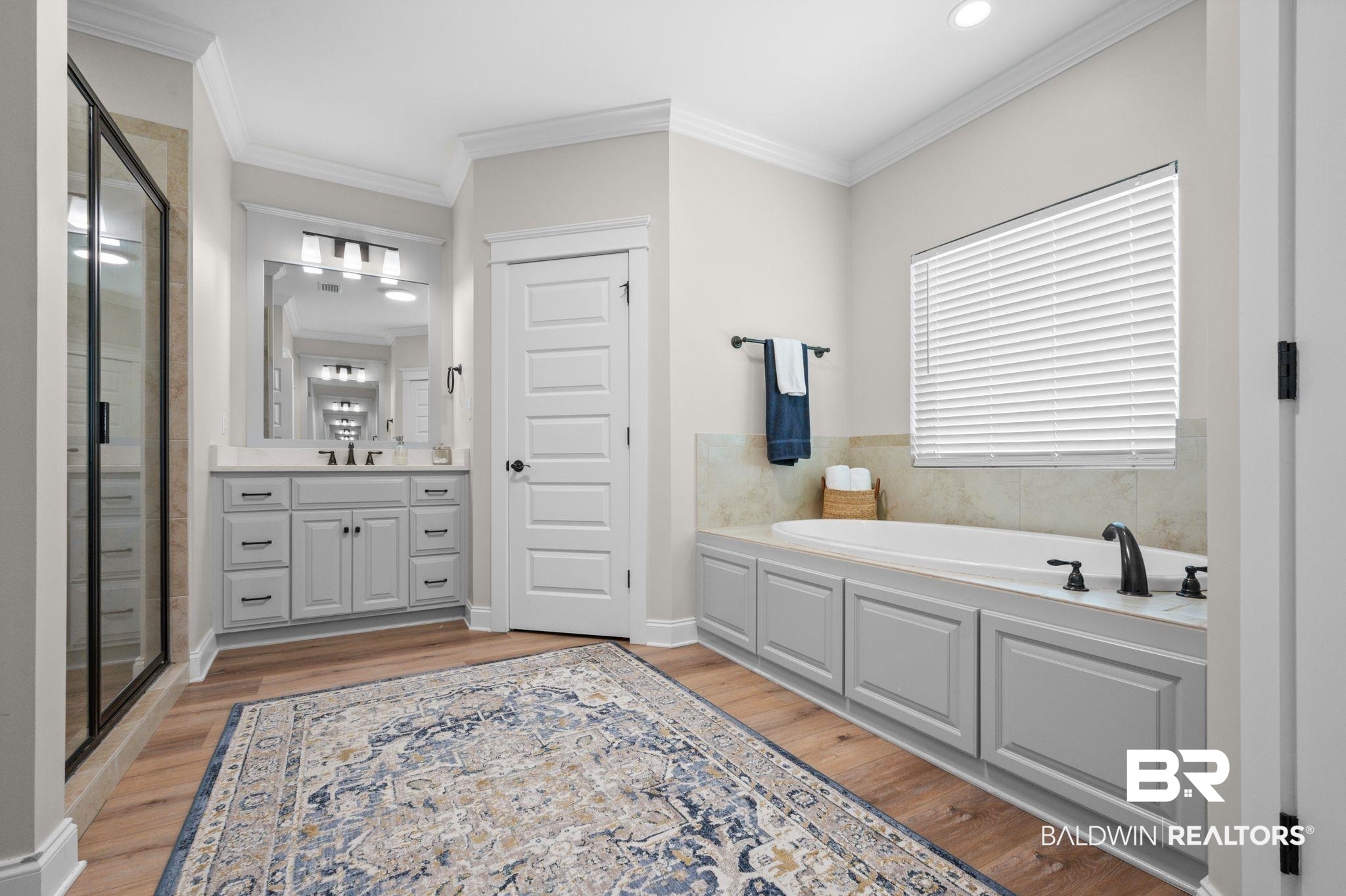 409 Fortune Drive Fairhope, AL 36532 - Photo 17 of 42 Bathroom featuring a built-in soaking tub with dark bronze fixtures, a vanity with stone-finish countertop, and a glass-enclosed shower