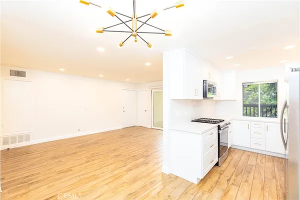 a view of a kitchen with a sink and wooden floor