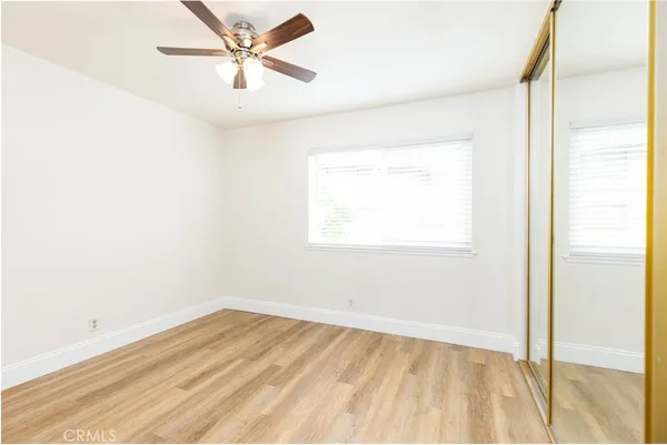 a view of a room with wooden floor and a ceiling fan