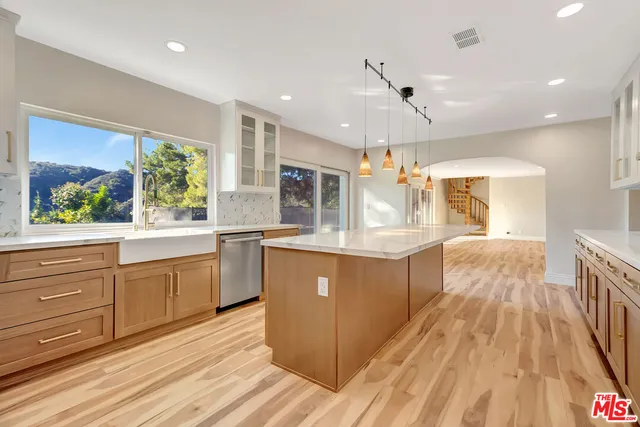 a kitchen with stainless steel appliances granite countertop a stove a sink and a microwave