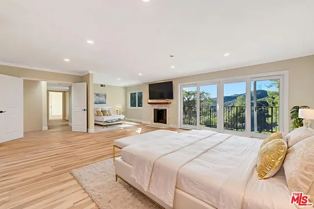a spacious bedroom with a bed and a potted plant
