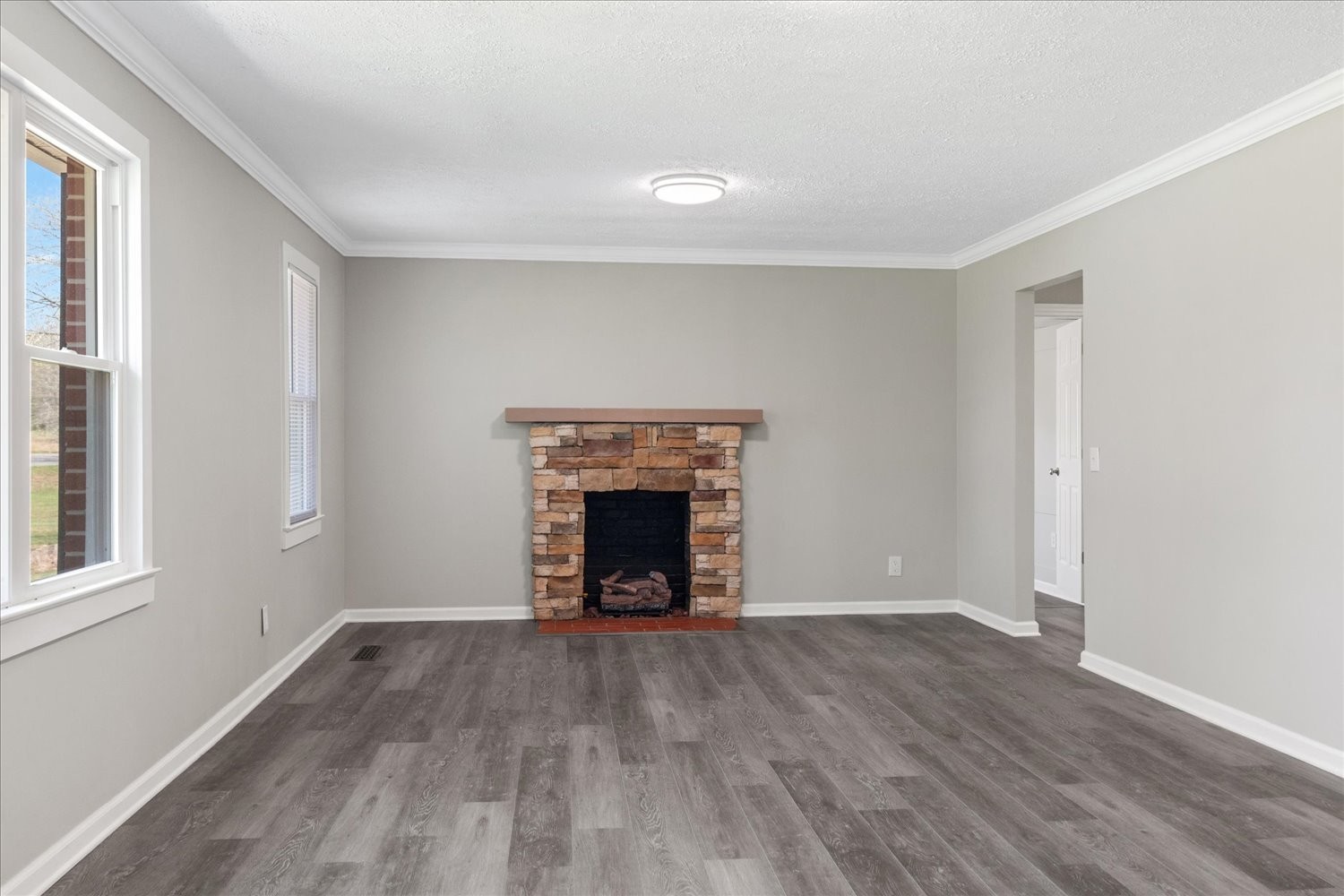 2540 Grays Bend Road Centerville, TN 37033 - Photo 23 of 48 an empty room with wooden floor fireplace and windows