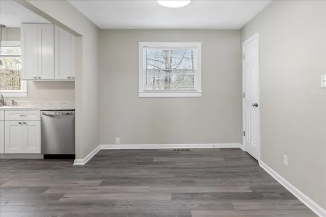 a view of a kitchen with wooden floor and windows