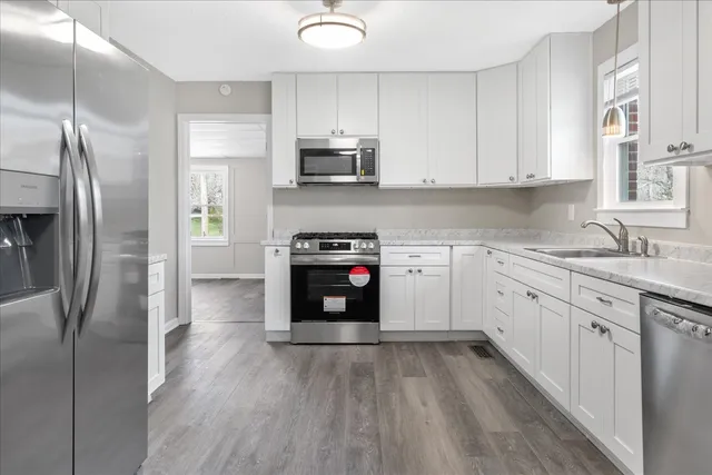 a kitchen with stainless steel appliances granite countertop a refrigerator sink and stove