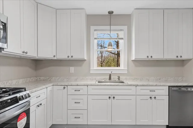 a kitchen with granite countertop white cabinets and white appliances