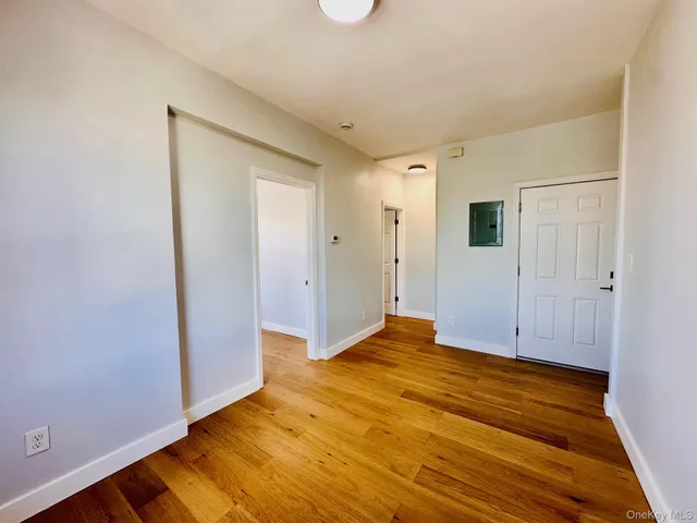 a view of empty room with wooden floor