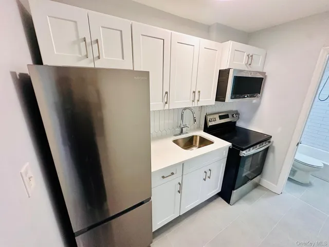 a kitchen with stainless steel appliances a refrigerator sink and cabinets