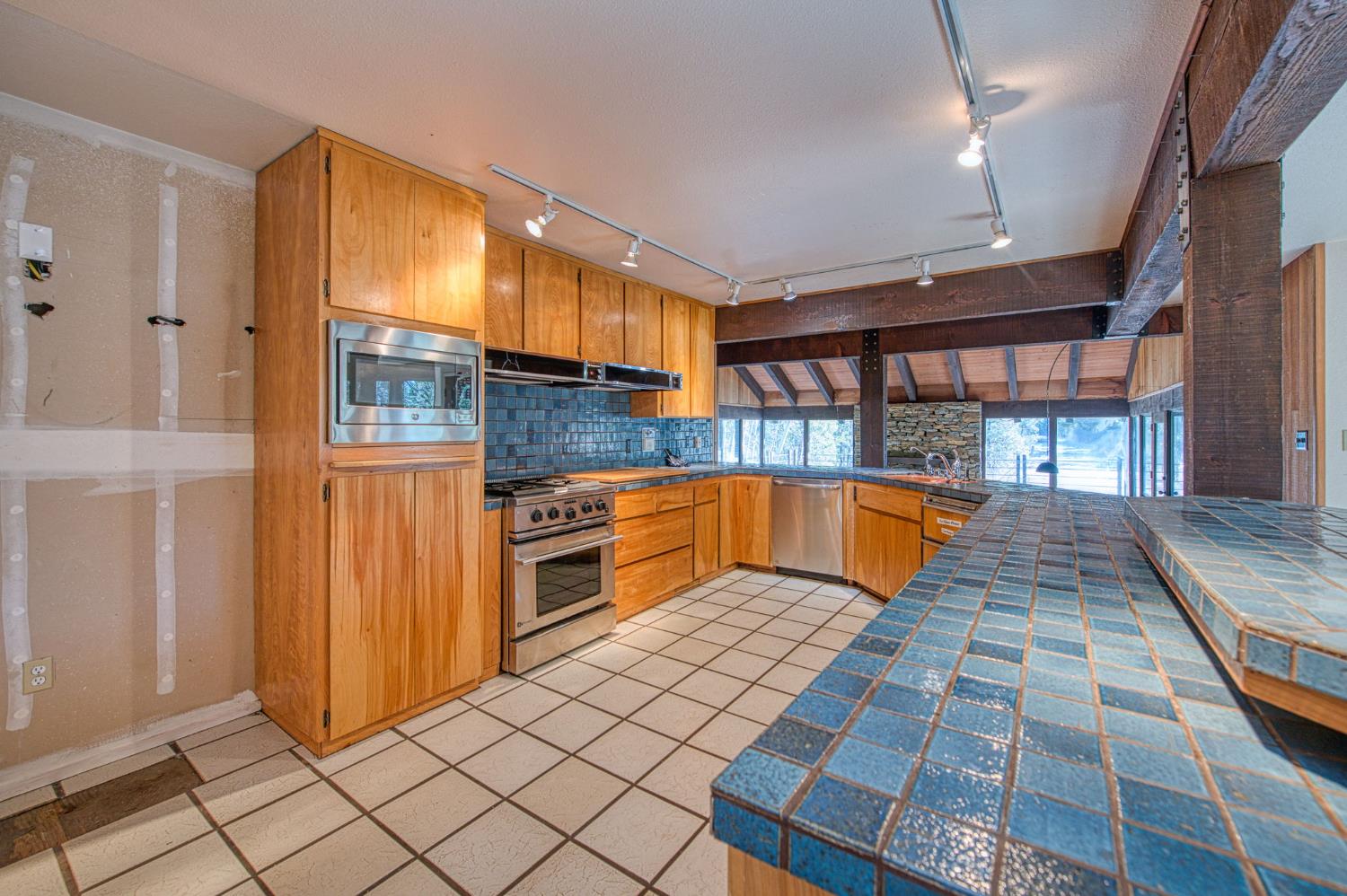 39326 Littlefield Road Shaver Lake, CA 93664 - Photo 16 of 49 a view of a kitchen with kitchen island granite countertop a refrigerator and a stove