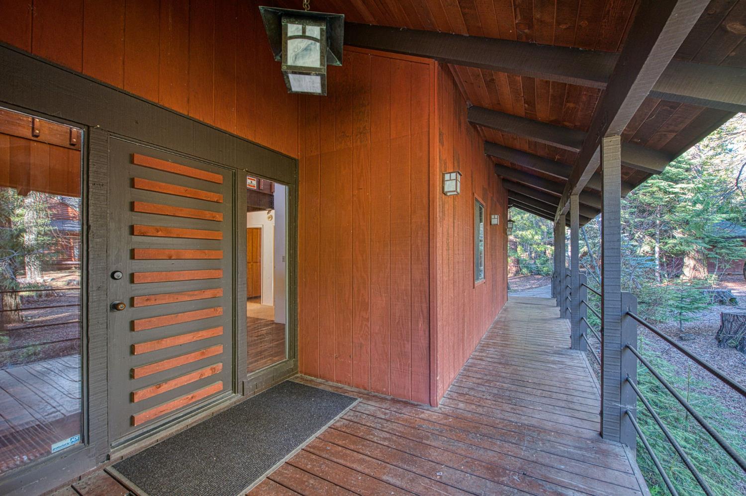 39326 Littlefield Road Shaver Lake, CA 93664 - Photo 40 of 49 a view of a hallway with wooden floor and a floor to ceiling window