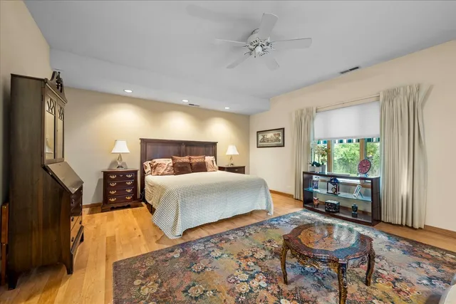 a spacious bedroom with a bed a couch and dresser