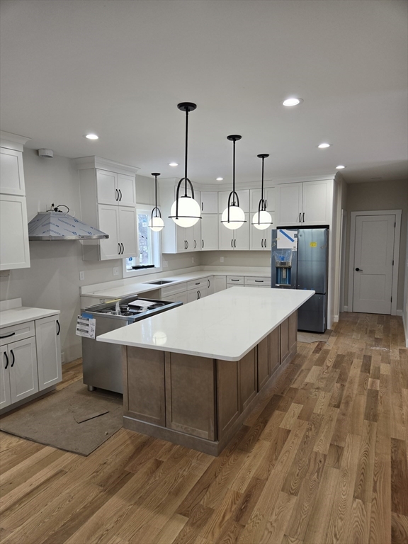 39 Tamarock Terrace Stoneham, MA 02180 - Photo 4 of 13 a large kitchen with a large counter top a sink stainless steel appliances and cabinets