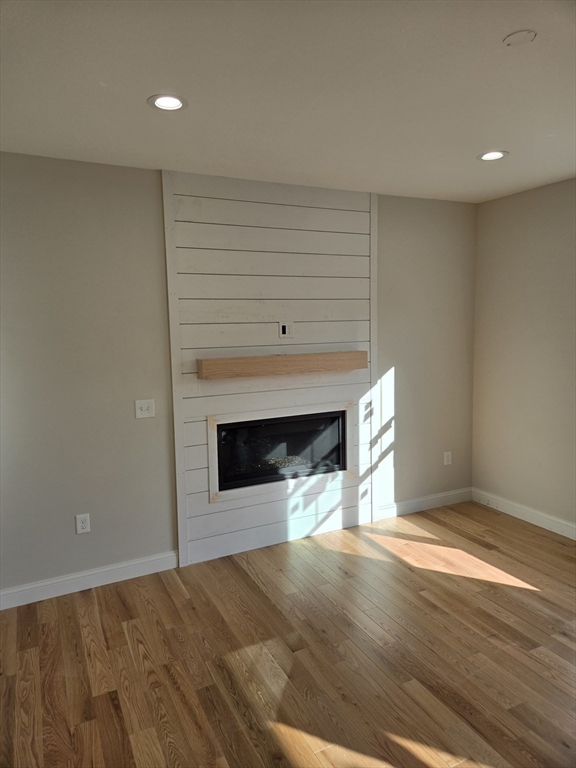 39 Tamarock Terrace Stoneham, MA 02180 - Photo 6 of 13 a view of empty room with wooden floor and fireplace