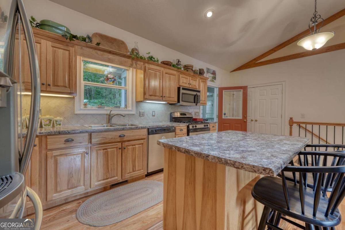 523 Sunnyside Shores Road Hiawassee, GA 30546 - Photo 12 of 55 a kitchen with stainless steel appliances granite countertop a sink dishwasher and microwave with wooden floor