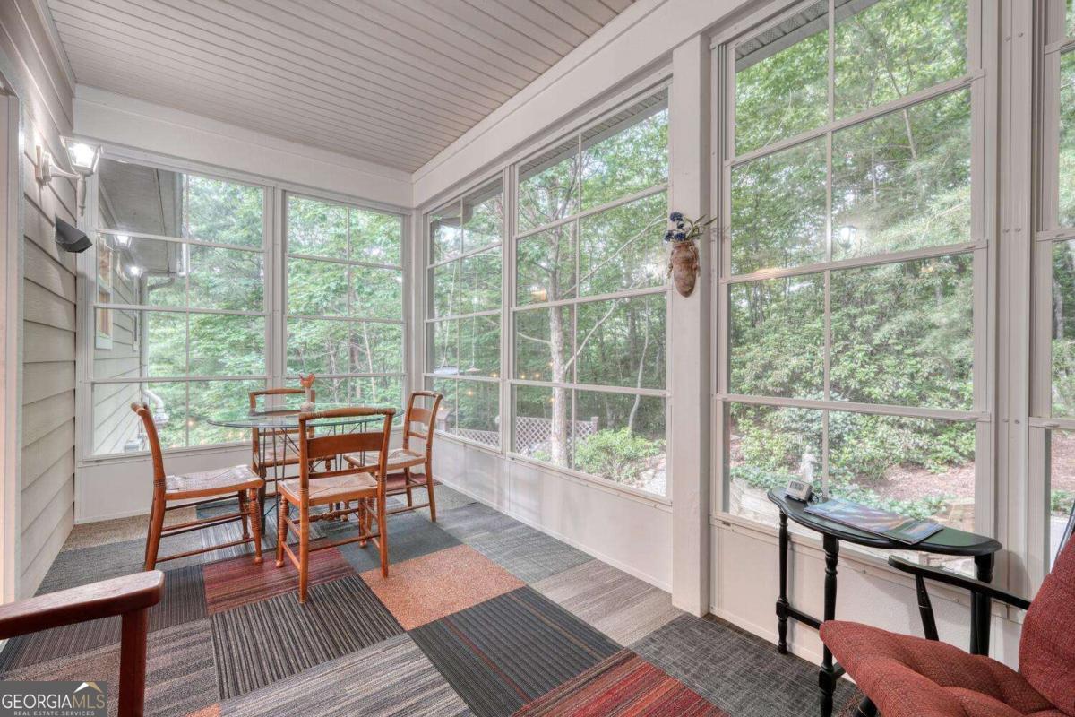 523 Sunnyside Shores Road Hiawassee, GA 30546 - Photo 26 of 55 a dining room with wooden floor a rug a table and a chairs