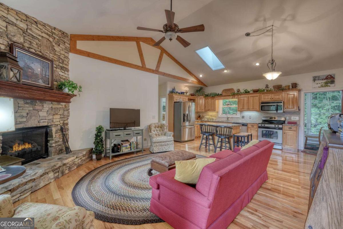 523 Sunnyside Shores Road Hiawassee, GA 30546 - Photo 8 of 55 a living room with furniture a flat screen tv and a fireplace