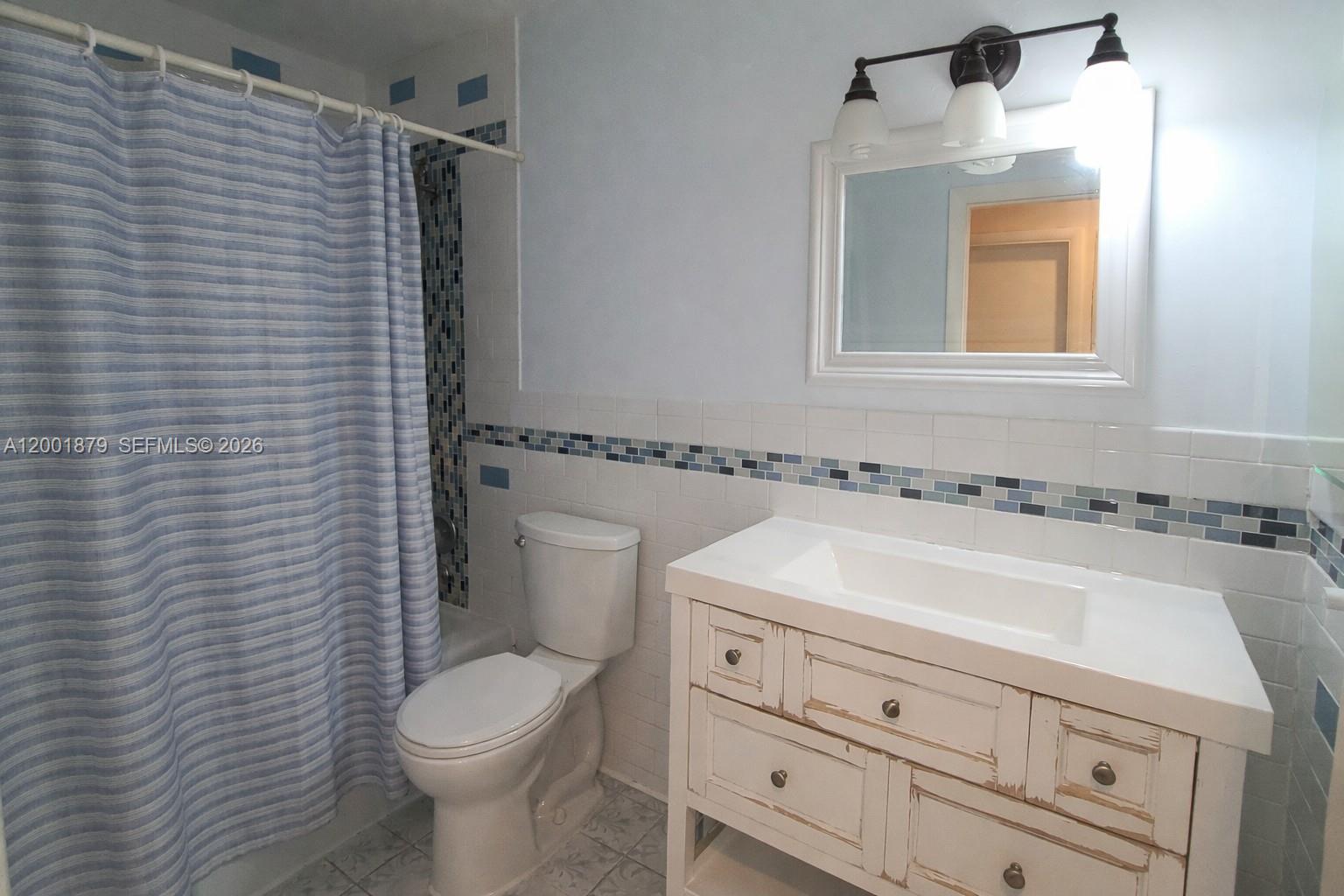 5524 Constant Spring Terrace, Unit 213 Lauderhill, FL 33319 - Photo 14 of 16 a bathroom with a sink a toilet and mirror