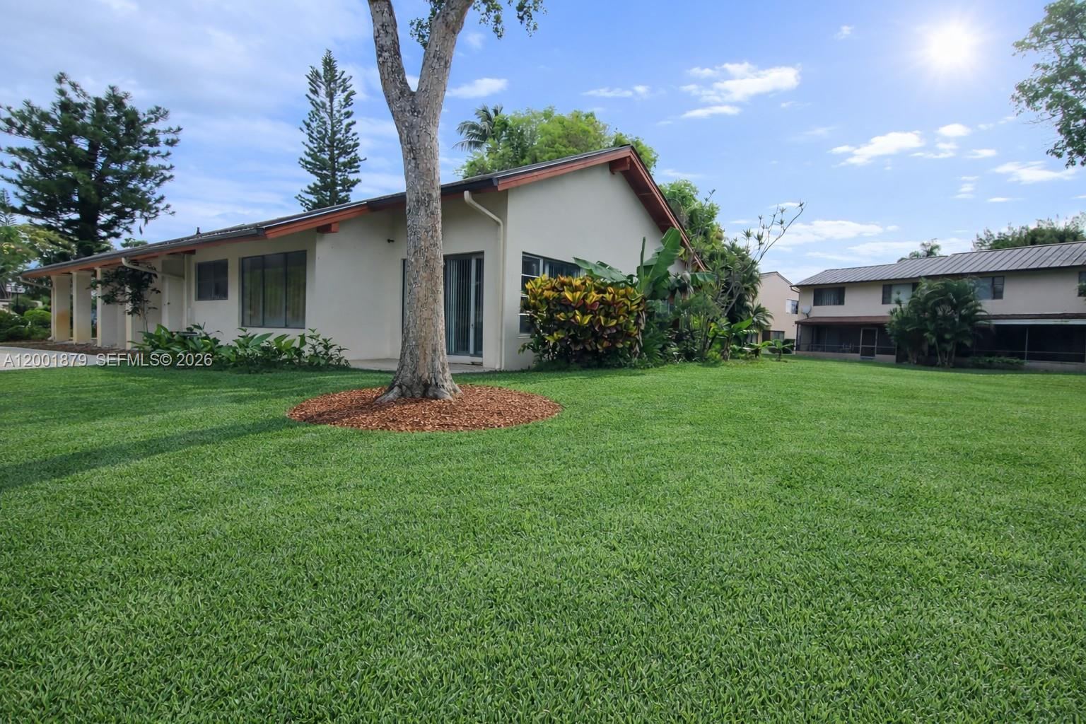 5524 Constant Spring Terrace, Unit 213 Lauderhill, FL 33319 - Photo 16 of 16 a view of a backyard with plants and large tree