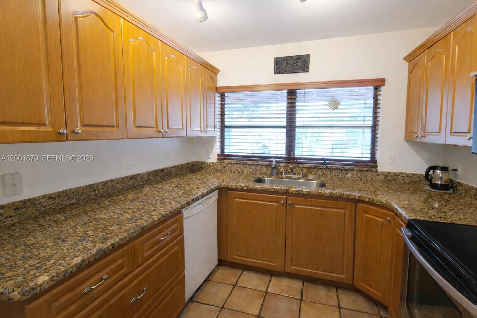 5524 Constant Spring Terrace, Unit 213 Lauderhill, FL 33319 - Photo 8 of 16 a kitchen with stainless steel appliances granite countertop a sink stove and cabinets