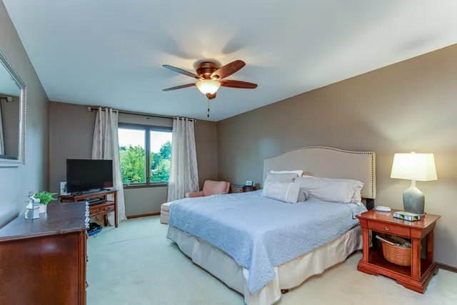 a bedroom with a bed window and a flat screen tv