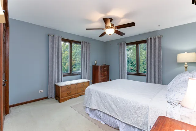 a bedroom with a bed and a large window