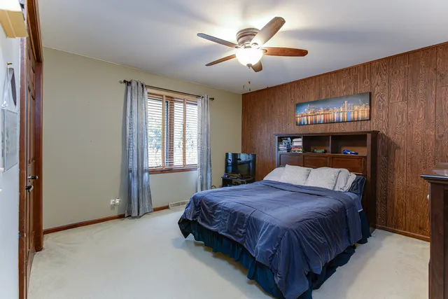 a bedroom with a large bed and a chandelier