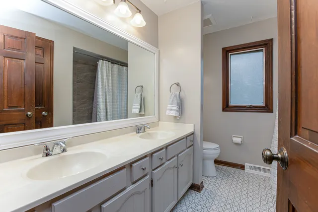 a bathroom with a double vanity sink and a mirror
