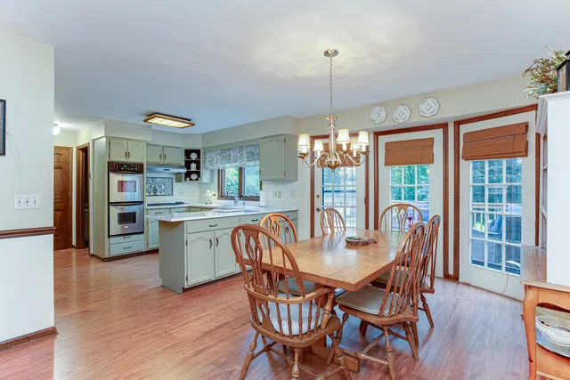 a dining room with furniture a chandelier and wooden floor
