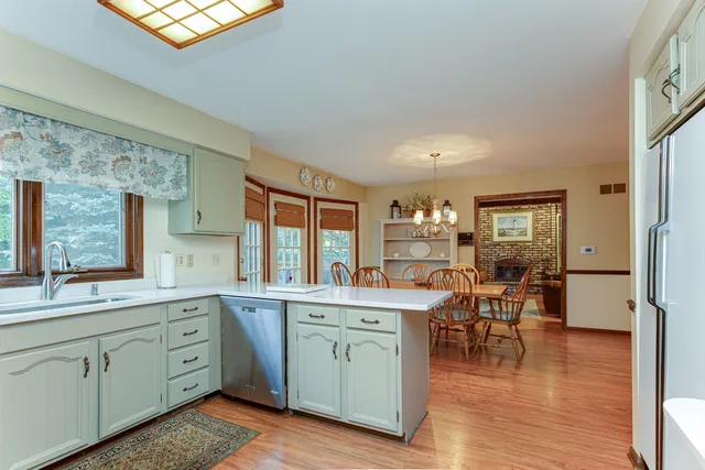 a open kitchen with white cabinets and wooden floor