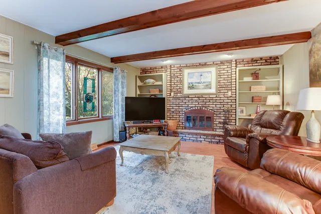 a living room with furniture a flat screen tv and a large window