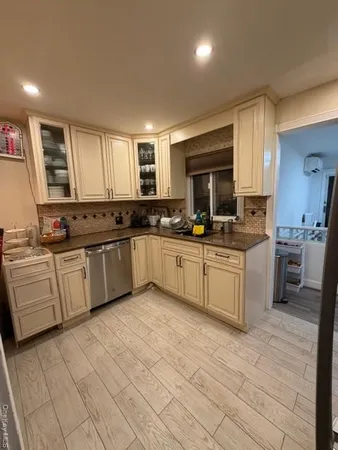 a large kitchen with cabinets a sink a window and stainless steel appliances