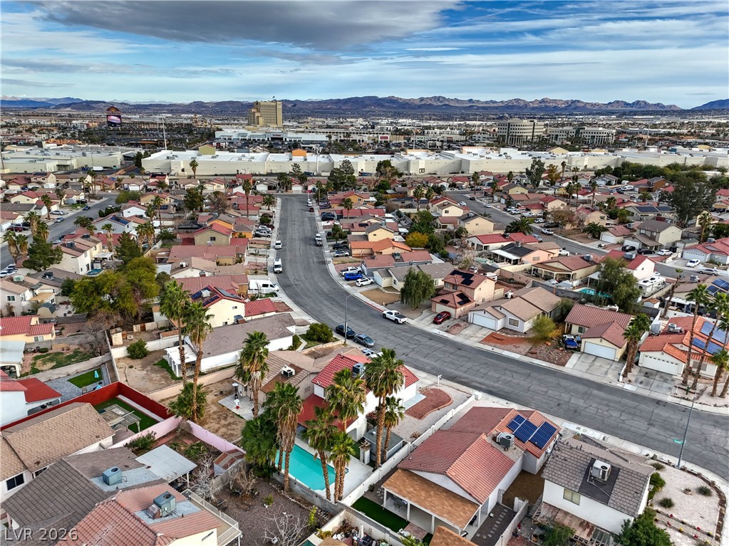 581 Carleton Drive Henderson, NV 89014 - Photo 33 of 37 An aerial perspective reveals a vibrant neighborhood with individual pools, mature palm trees, and mountain views.
