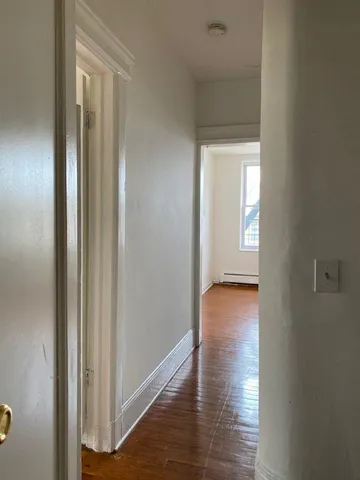 a view of a hallway with wooden floor