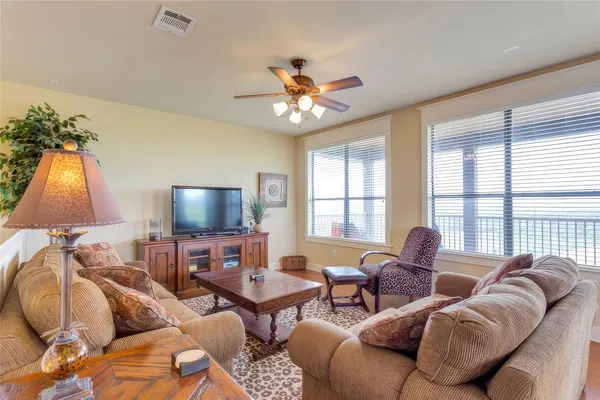 a living room with furniture a ceiling fan and a window