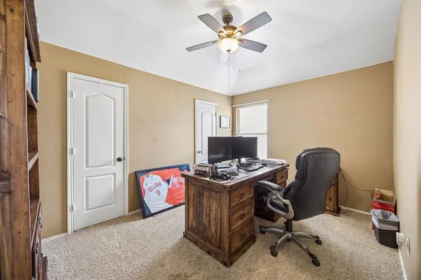 a view of a workspace with furniture and a window