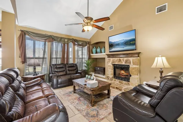 a living room with furniture a fireplace and a flat screen tv