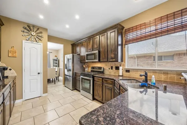 a kitchen with stainless steel appliances granite countertop a sink stove and refrigerator