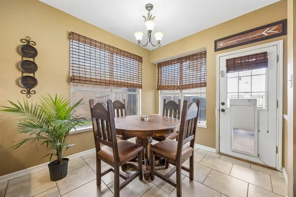 a dining room with furniture potted plants and wooden floor