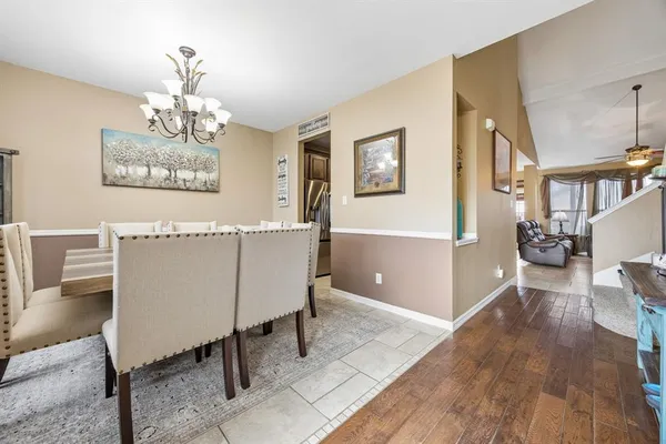 a view of a livingroom with furniture a chandelier and wooden floor