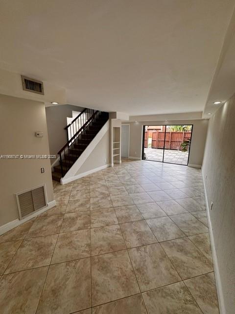 6724 Southwest 114th Place, Unit F Miami, FL 33173 - Photo 6 of 27 a view of an empty room with stairs and a window
