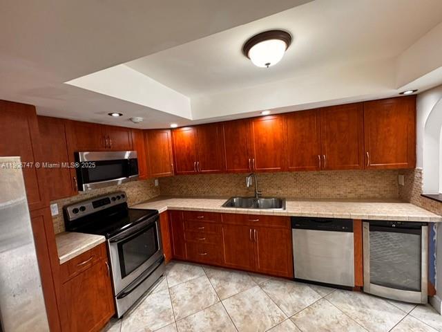 6724 Southwest 114th Place, Unit F Miami, FL 33173 - Photo 10 of 27 a kitchen with stainless steel appliances granite countertop wooden cabinets a stove a sink and a microwave