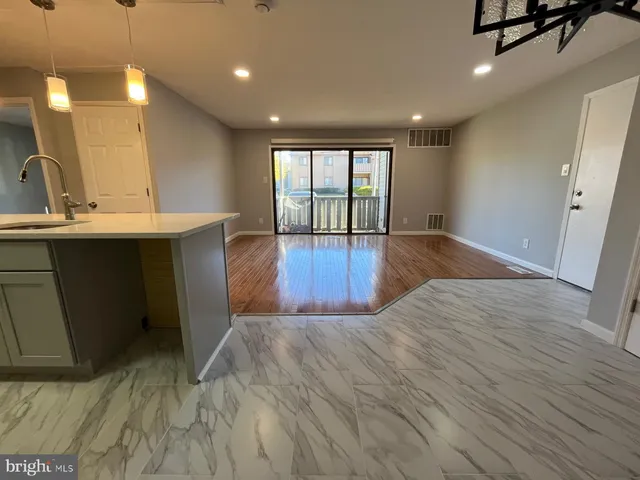 a large room with wooden floor and natural light
