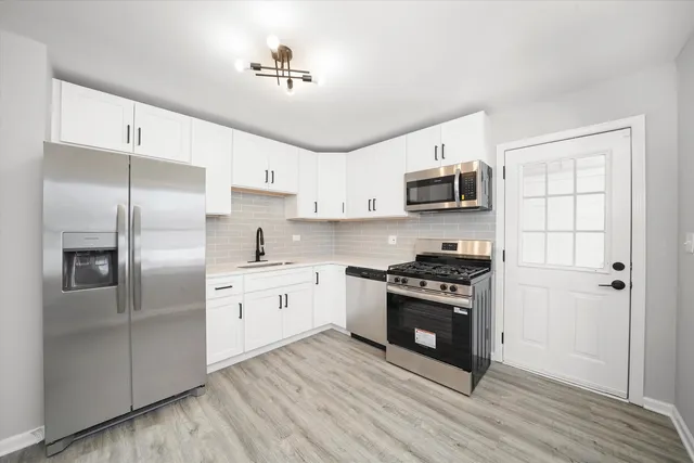 a kitchen with stainless steel appliances granite countertop a stove a sink and a refrigerator