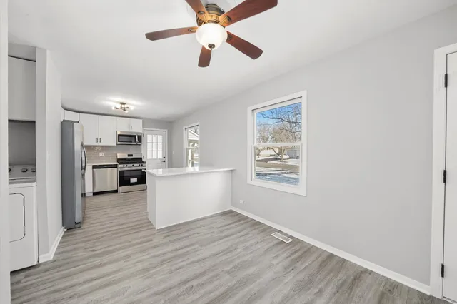 a view of a kitchen with wooden floor and a kitchen