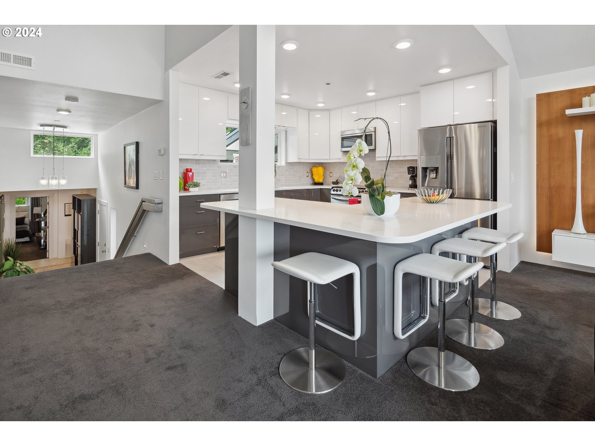 5427 Southwest View Point Terrace Portland, OR 97239 - Photo 25 of 40 a kitchen with stainless steel appliances kitchen island granite countertop a table chairs and a refrigerator