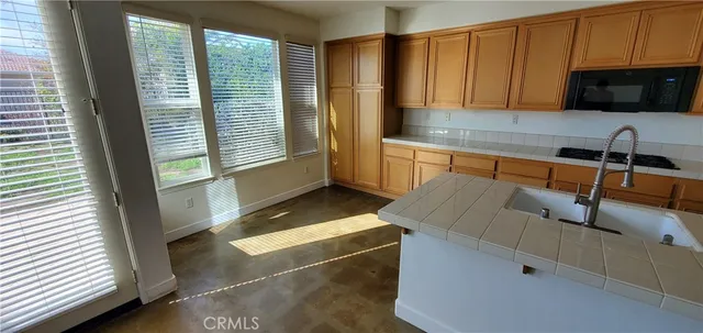 a kitchen with granite countertop a sink and a stove top oven