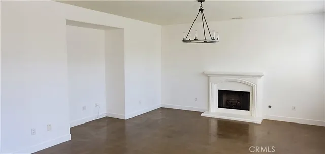an empty room with a fireplace and wooden floor